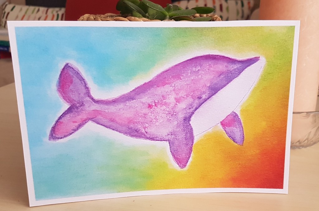 Peinture aquarelle d'une baleine violette aux couleurs cosmiques sur fond arc-en-ciel.